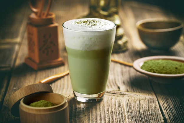 Lớp kem phô mai béo mặn sánh mịn phủ trên ly matcha latte