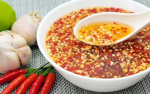 Nước chấm bún chả màu hổ phách với tỏi ớt nổi