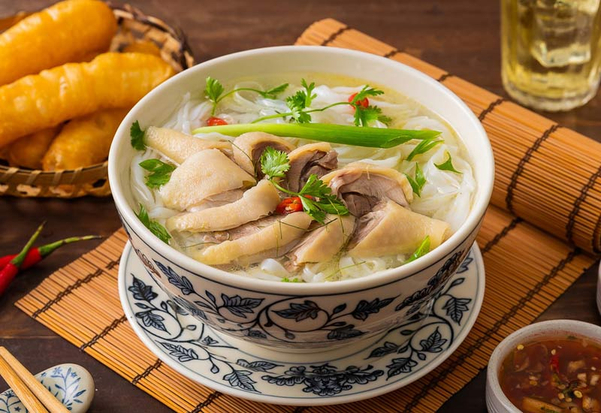 Bát phở nóng hổi, nước dùng vàng mơ lấp lánh mỡ gà, điểm xuyết lá chanh thơm nức mũi.